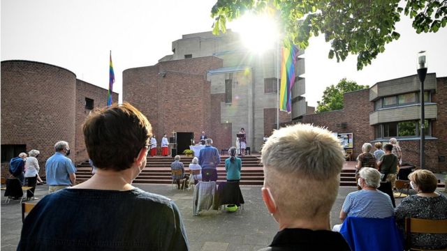 Parejas en una bendición afuera de una iglesia católica en Colonia.