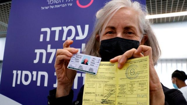 Una mujer en Israel muestra su certificado de vacunación
