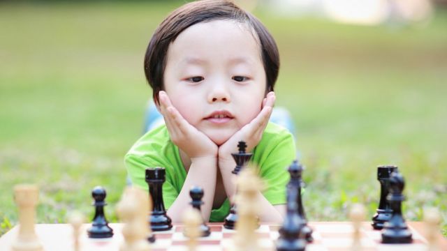 Criança joga xadrez em sala de aula na escola xadrez para criança  inteligente gênio infantil aluno inteligente jogando l