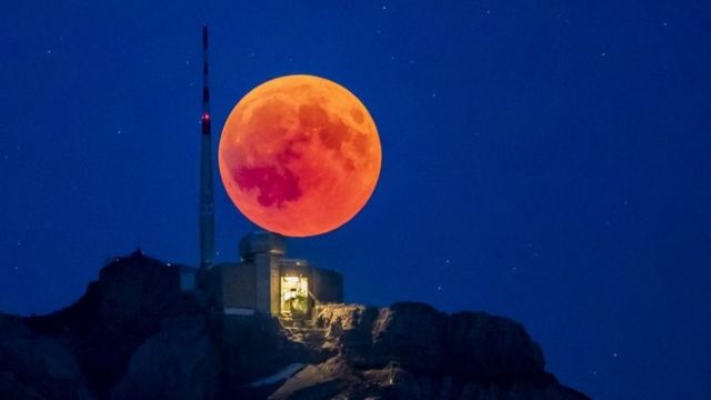Mwezi mwekundu unapanda nyuma ya Saentis (2502m) Alpstein, nchini Uswizi