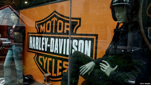 he Harley Davidson logo is displayed in a window of Harley-Davidson of New York City store