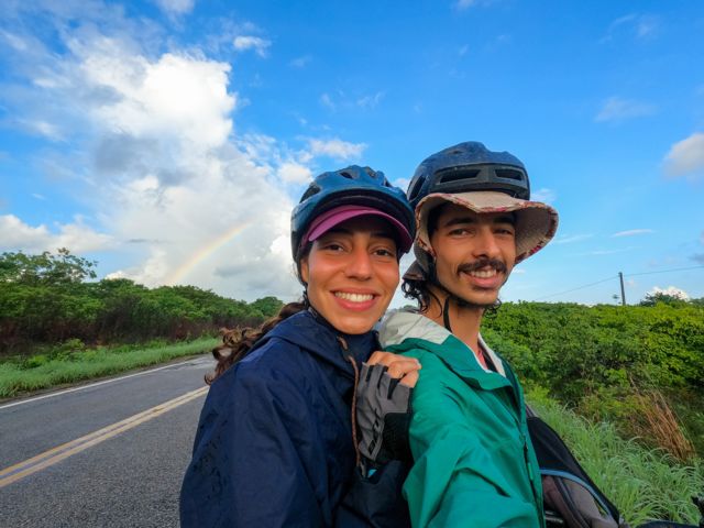 Casal com arco-íris ao fundo na estrada no inverno cearense - CE, em 2023