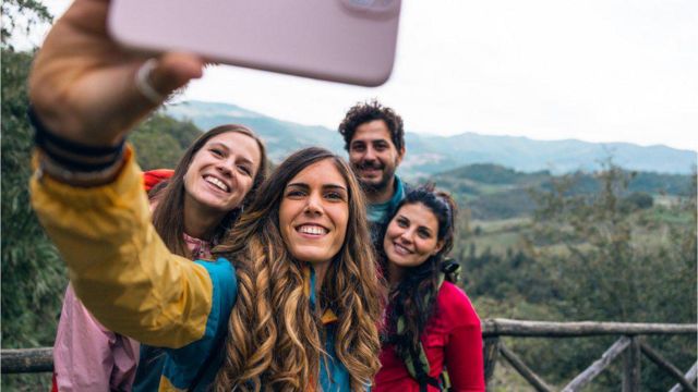 Pessoas tirando selfie em área verde