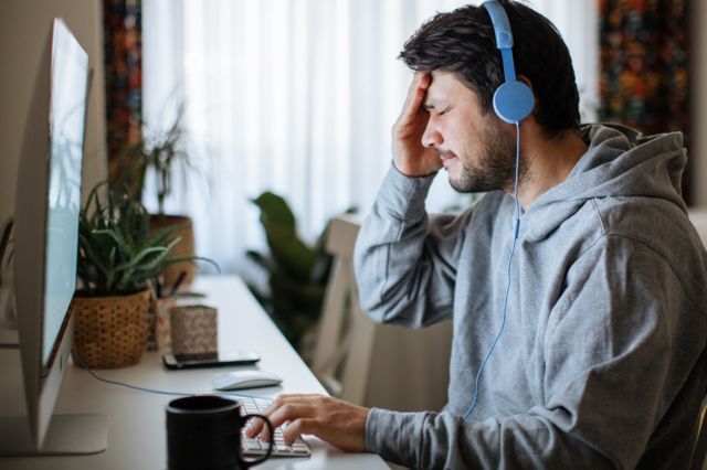 homem com expressão de preocupação em frente ao computador