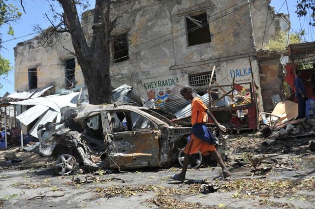 صبي يسير بالقرب من موقع هجوم بسيارة مفخخة بالقرب من نقطة تفتيش أمنية في العاصمة الصومالية، على مقربة من القصر الرئاسي في مقديشو في 7 مارس/ آذار 2019 في هجوم تبنته حركة الشباب الجهادية. 