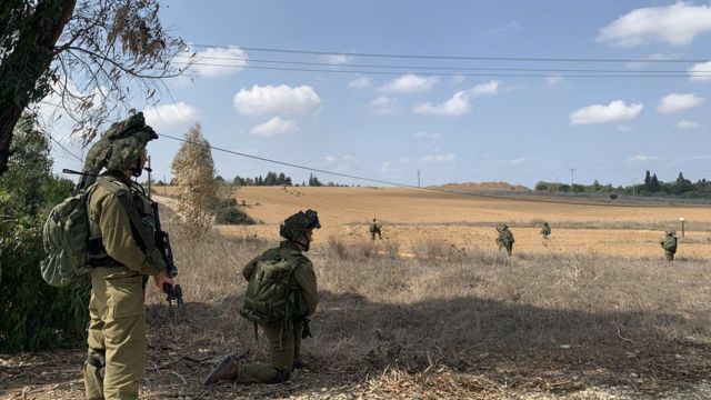 Tropas israelíes hacen guardia frente al kibutz de Kfar Aza.