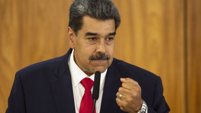 O presidente da Venezuela, Nicolás Maduro. Ele usa terno escuro, camisa branca e gravata vermelha. No pulso, usa um relógio prateado