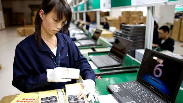 Mujer trabajando en la producción de computadoras chinas.