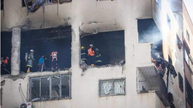 رجال الدفاع المدني الفلسطيني يكافحون النيران المشتعلة في شقة سكنية استهدفها قصف إسرائيلي أسفر عن مقتل شخصين بينهم قيادي في حركة الجهاد الإسلامي