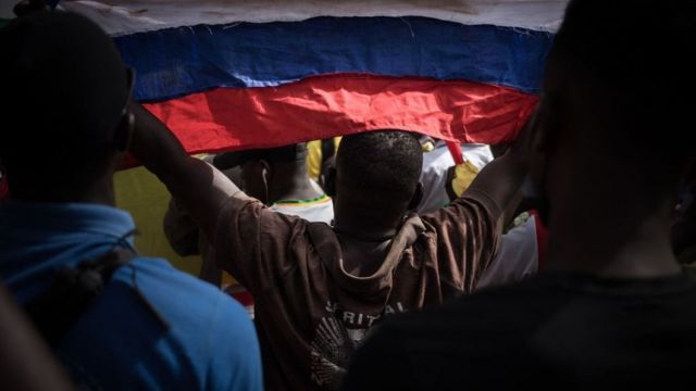 A protester holds a Russian flag during a demonstration celebrating France's announcement to withdraw its troops from Mali