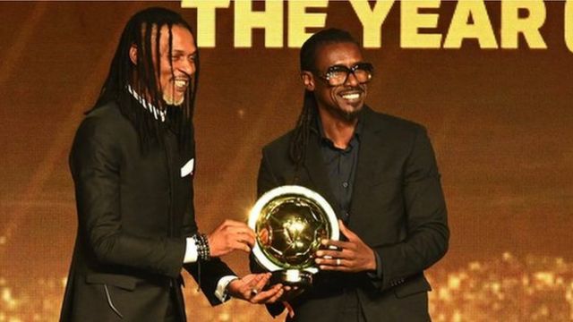 Rigobert Song presents Aliou Cissé with his Caf National Men's Coach of the Year award.