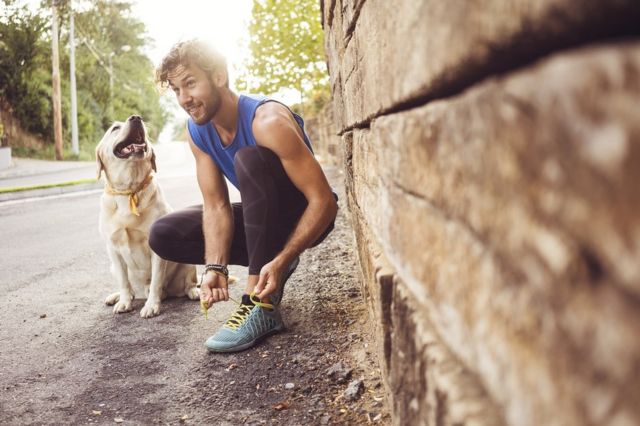 Un joven y su perro salen a correr.