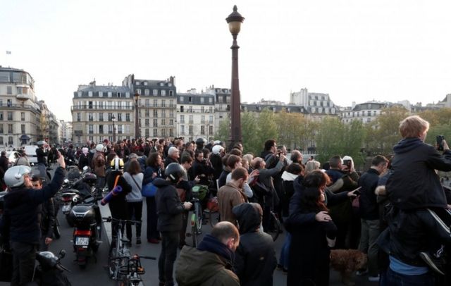 People gather on a bridge to watch the blaze