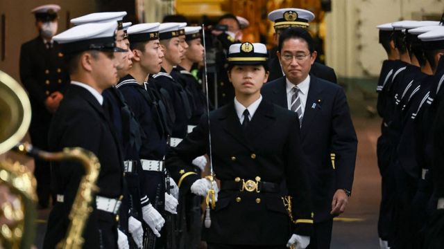 Japan's Prime Minister Fumio Kishida (centre R-facing) receives an honorary salute aboard the Japanese helicopter carrier JS Izumo during an "International Fleet Review", held by Japan's Maritime Self-Defense Force with some 12 other countries, in Sagami Bay, off Kanagawa Prefecture, on November 6, 2022