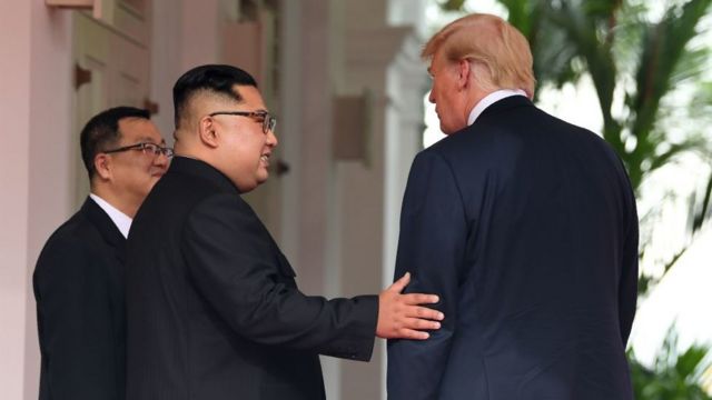 North Korea's leader Kim Jong Un (C) gestures as he meets with US President Donald Trump (R)