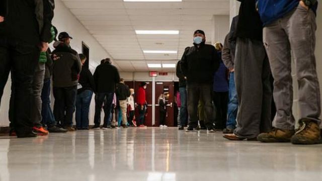 Residents of Louisville, Kentucky line up at a school that is used as TPS.