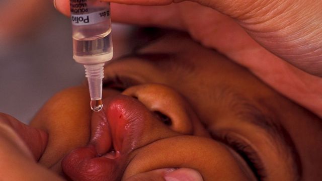 Criança toma vacina contra poliomielite em clínica brasileira