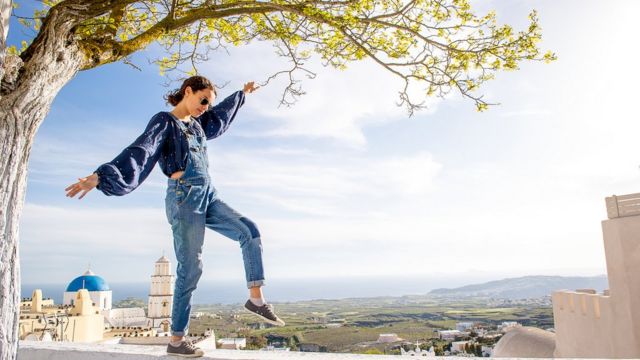 Beneficios que puede traerte el pararte en un solo pie Chica balanceándose sobre muro