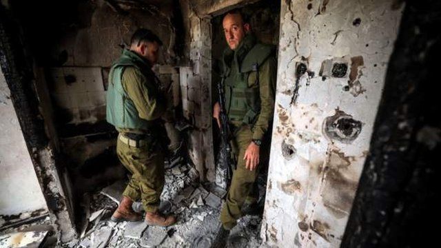 Israeli soldiers on Friday inspect a house damaged in the Hamas attack of 7 October