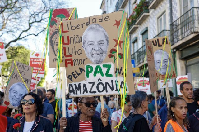 Na rua, mulher levanta cartaz com rosto de Lula e dizeres: "Lula pela paz na Amazônia"