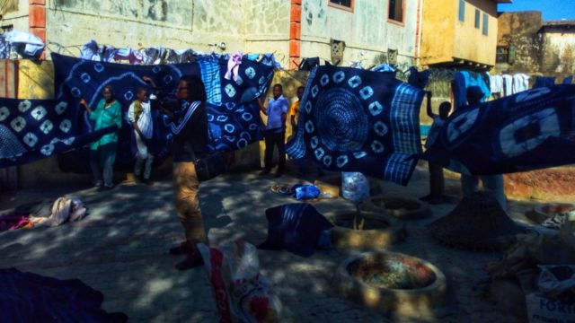 Men hang up freshly dyed blue cloths in Kano, Nigeria