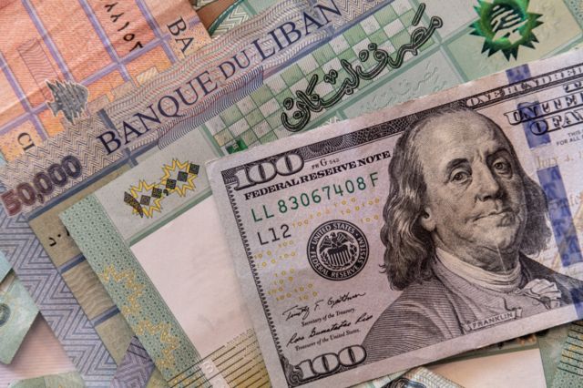 أوراق نقد لبنانية إلى جانب دولارات أمريكية
