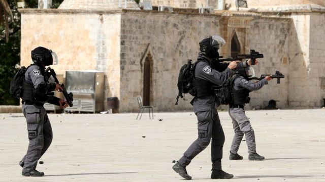 Israeli police officer aims a weapon during clashes with Palestinians around the al-Aqsa mosque in occupied East Jerusalem (10 May 2021)