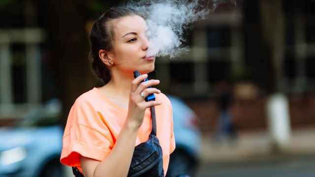 Mulher fumando cigarro eletrônico