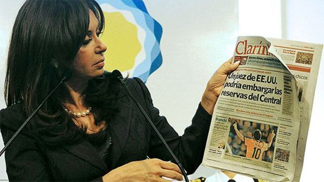 Cristina Kirchner sosteniendo una portada del diario Clarín