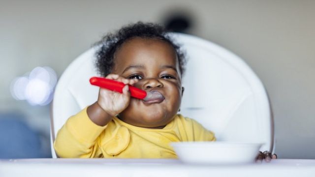 Bebê se alimenta em cadeirinha