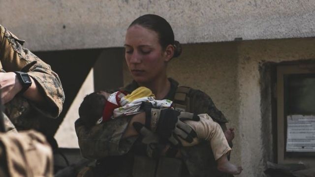US Marine Sgt Nicole Gee, holding an Afghan baby
