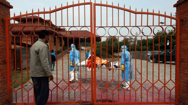 कोभिड-१९ का कारण मृत्यु भएका आफन्तको पार्थिव शरीरलाई टाढाबाटै नमस्कार गर्दै एक आफन्त