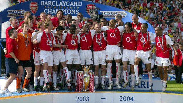 Arsenal players celebrate with Premiership trophy after becoming the 2003-2004 Premier League champions