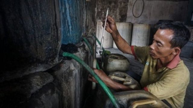 Pekerja mengukur kadar alkohol saat proses produksi pembuatan etanol atau alkohol 90 persen dari fragmentasi tebu di Sentra Industri Alkohol, Bekonang, Sukoharjo, Jawa Tengah, Rabu (20/1/2021).