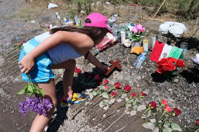 Uma jovem deixa flores no local onde o caminhão foi encontrado