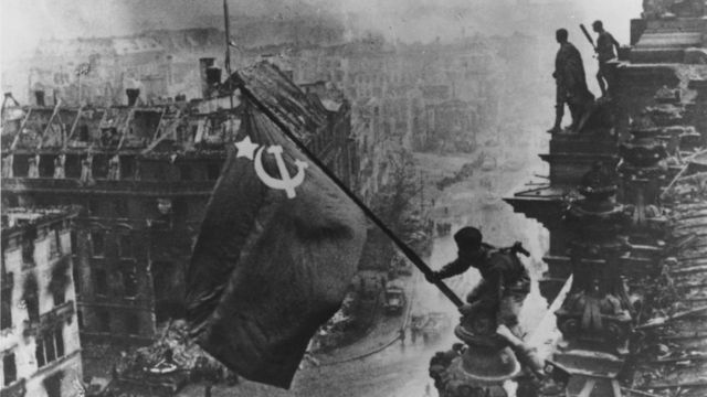 Un soldado ruso eleva la Bandera Roja sobre las ruinas del Reichstag en Berlín.
