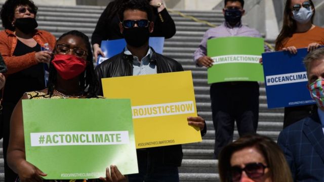 Miembros del partido Demócrata con carteles sobre el cambio climático
