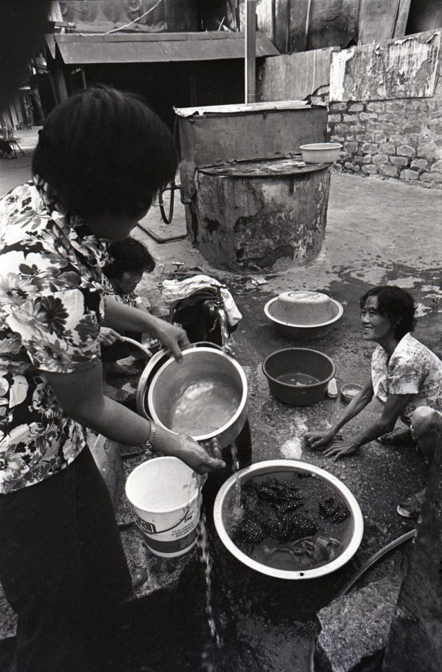 Mujeres limpiando cazuelas en la calle
