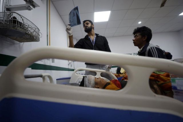 Equipe médica examina raios X de uma vítima do terremoto no Hospital Bheri em Nepalgunj, Nepal, 4 de novembro de 2023.