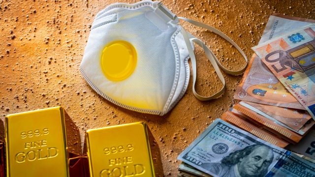 Money and gold bars near a face mask