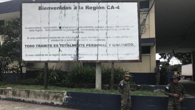 Militares de pie frente a una valla que dice "Bienvenidos a la región CA-4".