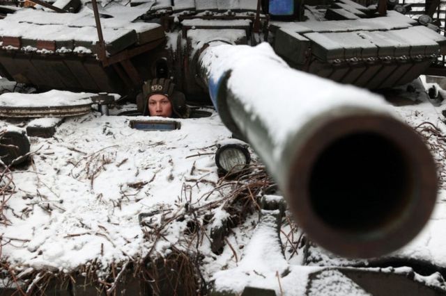 一名乌克兰士兵在顿涅茨克地区巴赫穆特镇附近坚守阵地，从一辆坦克中向外望去（2023年12月13日）