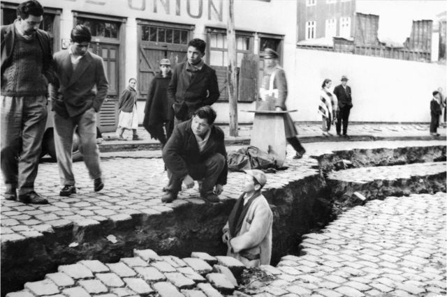 Hombres entre las grietas causadas en el suelo en el terremoto de Valdivia, Chile, en 1960