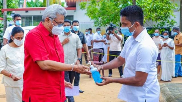 வாக்களிக்க செல்லும் முன்னர் தமது கைகளை சுத்தப்படுத்த சேனிடைசர் பெறும் இலங்கை ஜனாதிபதி கோட்டாபய ராஜபக்ஷ