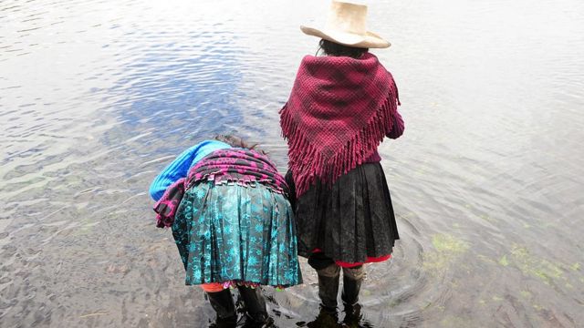 Dos indígenas en un lago