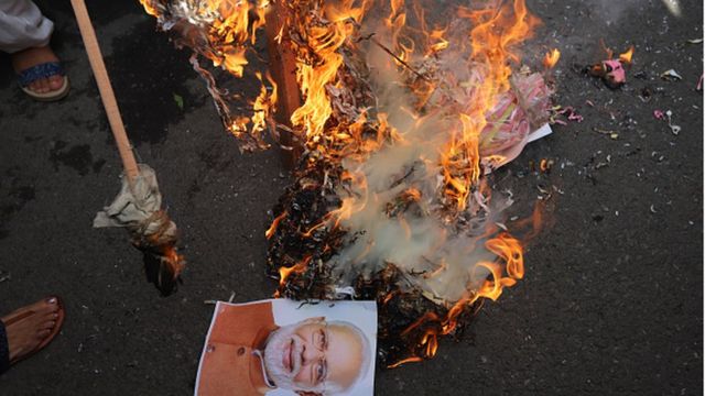 Members of the Congress women's wing burn the effigy of PM Narendra Modi to burn during a protest against alleged rape, murder and forceful cremation of a 9 year old girl, in Delhi.