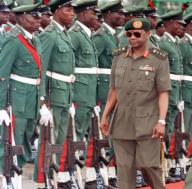 La photo de 1996 montre Sani Abacha à l'aéroport d'Abuja devant des soldats
