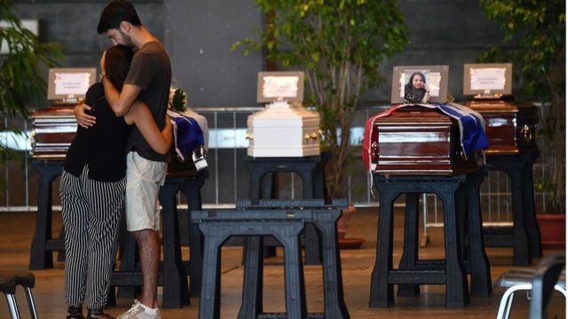 Mourners hold each other by the coffin of a victim of the Morandi bridge collapse in Genoa, on August 17, 2018.