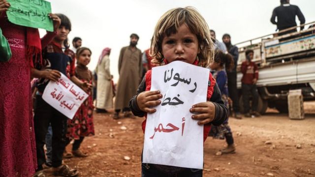 طفلة تحمل لافتة تندد بالسخرية من النبي محمد