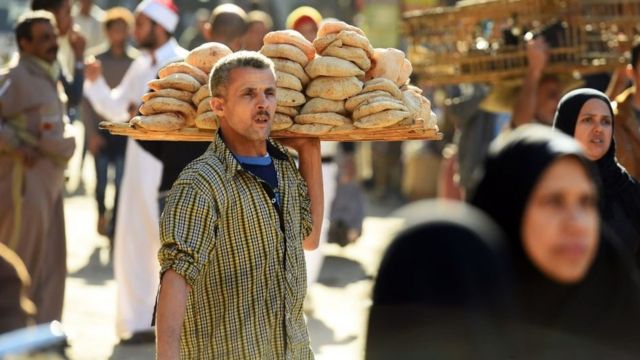 An Egyptian sells bread outside the al-Azhar mosque in Cairo on December 8, 2017.